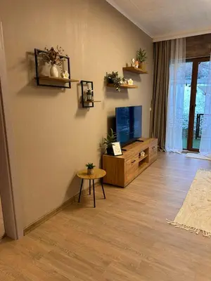 a living room with a tv and a table at Apart-Hotel Crow Bansko 3 in Bansko