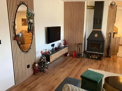 a living room with a christmas tree and a mirror at Студио за гости Петрови in Bansko