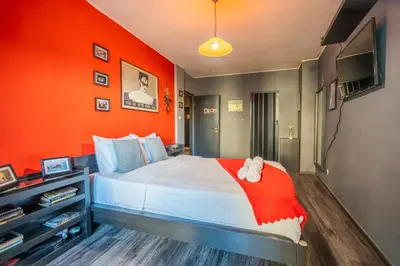 a bedroom with an orange wall and a bed at Free parking 1BR Tokuda Lozenets in Sofia
