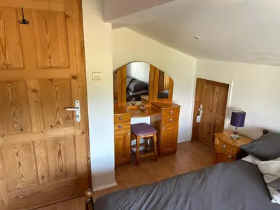 a bedroom with a bed and a desk and a mirror at Relyovo Lodge in Relyovo