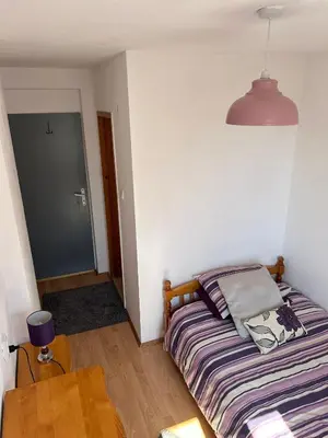 a small bedroom with a bed and a table at Relyovo Lodge in Relyovo