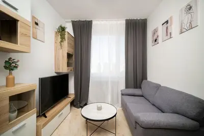 a living room with a couch and a tv at 2-Bedroom Apartment near Tokuda Hospital & Paradise Mall in Sofia
