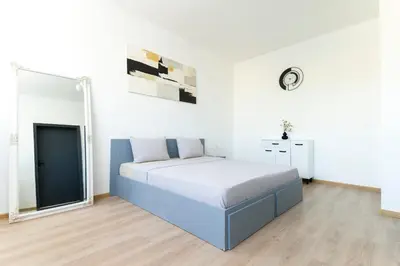 a bedroom with a large bed in a white room at 2-Bedroom Apartment near Tokuda Hospital & Paradise Mall in Sofia