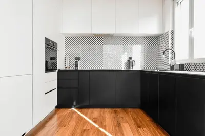 a kitchen with black and white cabinets and a wooden floor at View, Location, High End Interior, Lift, AC in Sofia