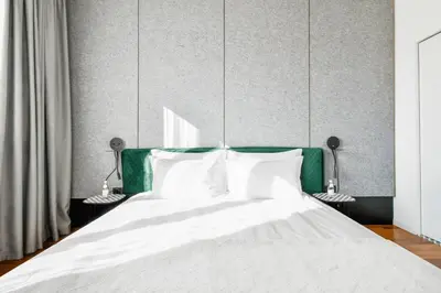 a bed with a green headboard and white pillows at View, Location, High End Interior, Lift, AC in Sofia