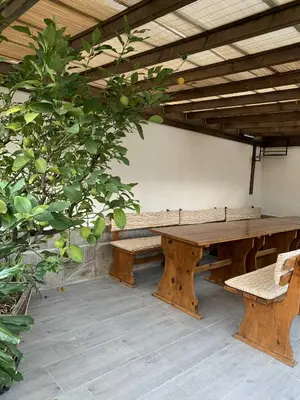 a wooden table and benches under a wooden roof at Пътепис in Bratsigovo