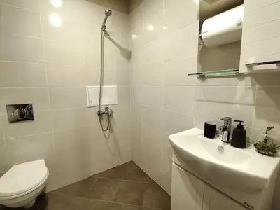 a white bathroom with a toilet and a sink at Cozy 1BR Mountain View Suite for 4 Guests in Bansko