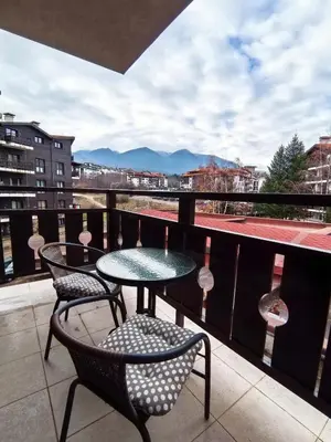 a balcony with two tables and chairs and a view at Cozy 1BR Mountain View Suite for 4 Guests in Bansko