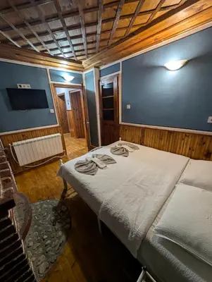 a bedroom with a bed in a room with a tv at Old House - Стара Къща in Koprivshtitsa