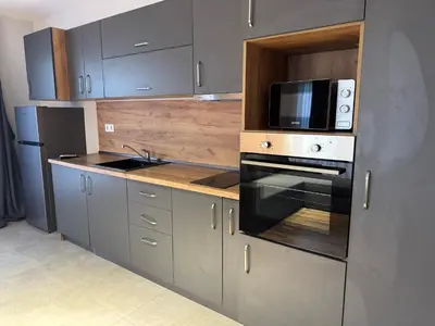 a kitchen with a microwave oven and a stove at MedHill Stay - Medical University Area in Plovdiv