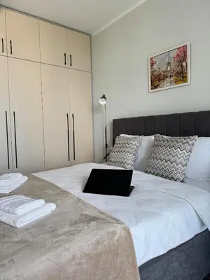 a bedroom with a bed with a laptop on it at Wings Apartment 1 Bedroom Luxury-free parking in Sofia