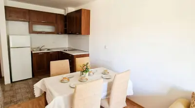 a dining room with a table with chairs and a kitchen at Penthouse Duplex Large 2 Bedroom MP1 in Bansko