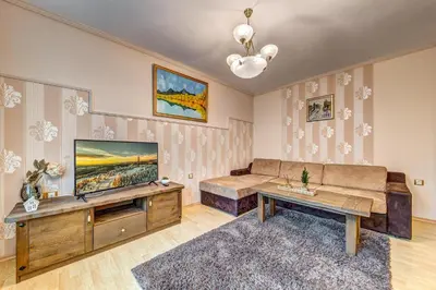 a living room with a couch and a tv at Апартамент Orpheus Forest in Pamporovo