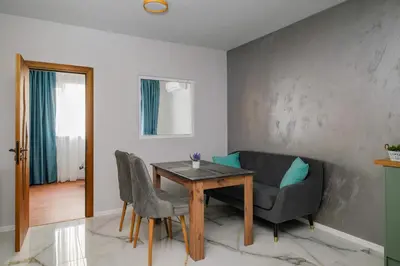 a dining room with a table and a couch at Stylish 1 Bedroom Apartment - Quiet & Comfortable in Sofia