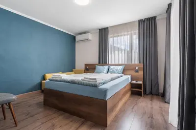 a bedroom with a bed with a blue wall at Къща за гости Мартинели