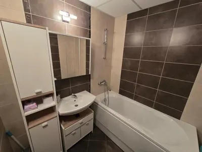 a bathroom with a sink and a tub and a mirror at AspenValley Aprtment in Razlog