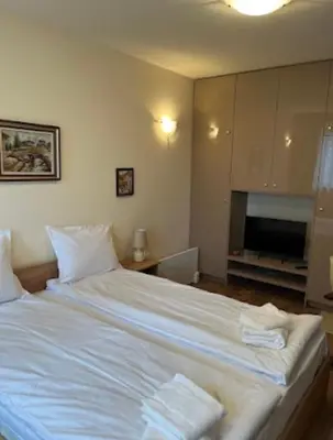a bedroom with a large white bed with two towels on it at Апартаменти за гости Алекс in Pamporovo