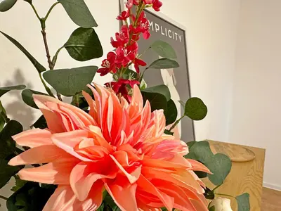 a vase filled with orange flowers next to a plant at Spacious bright cozy 2BDR fast Wi-Fi next to Park in Sofia