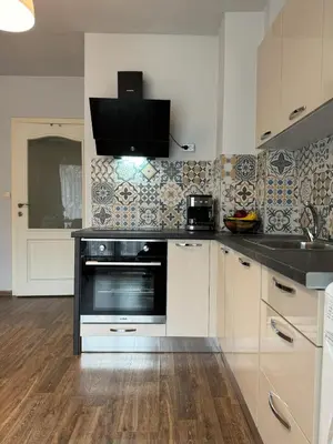 a kitchen with white cabinets and a black oven at Top Centre Plovdiv Apartment for 4 Guests & Parking in Plovdiv