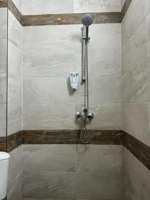 a shower in a bathroom with a tile wall at Top Centre Plovdiv Apartment for 4 Guests & Parking in Plovdiv