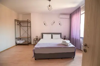 a bedroom with a large bed and a window at Apartments by the river 2 in Plovdiv