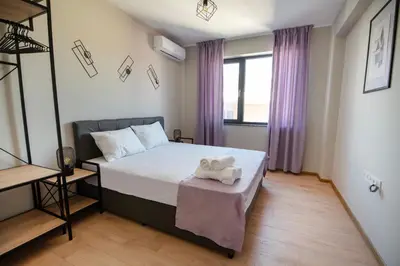 a bedroom with a bed with a stuffed animal on a table at Apartments by the river 2 in Plovdiv
