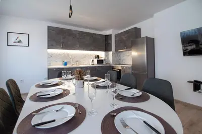 a dining room with a white table and chairs at Apartments by the river 2 in Plovdiv
