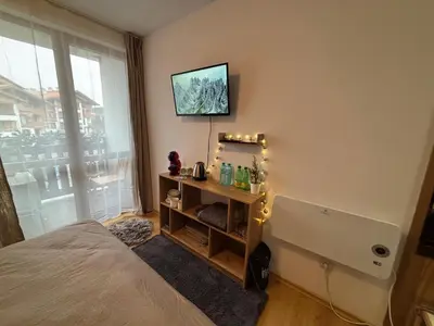 a bedroom with a bed and a television on the wall at Smart Stay - Refurbished Studio with Balcony and Parking in Bansko