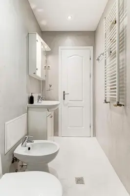 a white bathroom with a sink and a toilet at Prime Central Sofia Living Modern 2BR Apt in Sofia