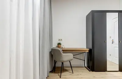 a desk with a chair in a room with curtains at Prime Central Sofia Living Modern 2BR Apt in Sofia