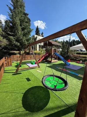 a playground with a tire swing on the grass at Iceberg Studio 15 in Borovets