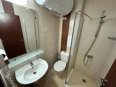 a bathroom with a toilet and a sink and a shower at Belmont urban one bedroom apartment in Bansko