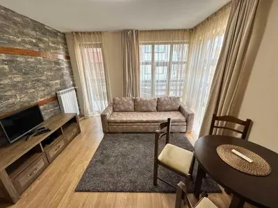 a living room with a couch and a table at Belmont urban one bedroom apartment in Bansko