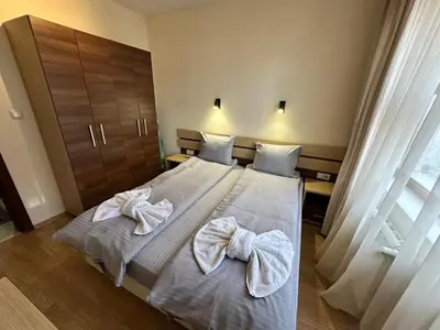 two beds in a hotel room with towels on them at Belmont urban one bedroom apartment in Bansko