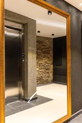 a mirror in a hallway with a stone wall at Plovdiv Hills Apartments with FREE Parking in Plovdiv