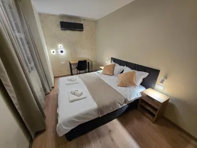 a bedroom with a large bed with white sheets and pillows at Plovdiv Hills Apartments with FREE Parking in Plovdiv