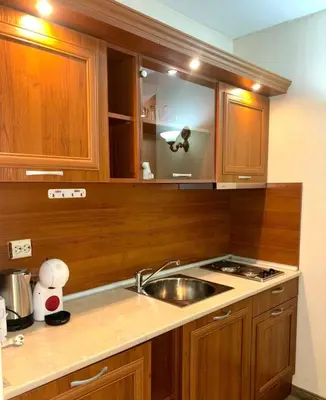 a kitchen with wooden cabinets and a sink at Еmerald Apartment Complex in Bansko