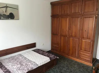 a bedroom with a bed and a large wooden cabinet at EAST Spacious and Comfort Apartment in the best suburb in Sofia in Sofia