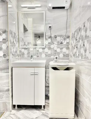 a white bathroom with a sink and a mirror at Top City Centre 1BDR Apartment next to Theater Tear and Laughter in Sofia