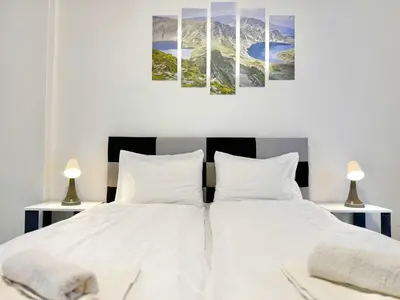a bedroom with two beds with white sheets and two lamps at Top City Centre 1BDR Apartment next to Theater Tear and Laughter in Sofia