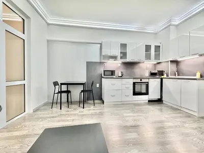 a kitchen with white cabinets and a table and chairs at Top City Centre 1BDR Apartment next to Theater Tear and Laughter in Sofia