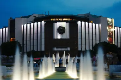 a large building with a fountain in front of it at Alex's Charming Apartment by NDK in Sofia
