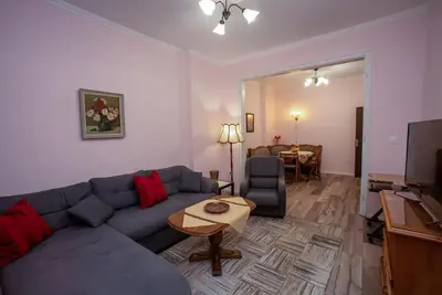 a living room with a blue couch and a table at Alex's Charming Apartment by NDK in Sofia
