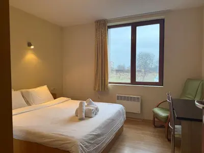a bedroom with a bed with a stuffed animal on it at Bansko Bliss - Peaceful Stay with Balcony Views in Bansko