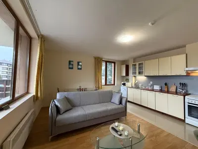 a living room with a couch and a glass table at Bansko Bliss - Peaceful Stay with Balcony Views in Bansko