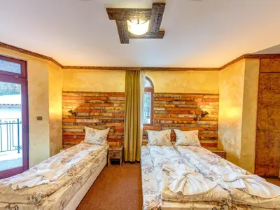 two beds in a room with a brick wall at Raikovski Livadi Mountain Villas Pamporovo in Smolyan