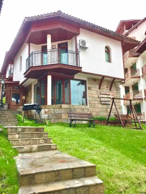 a house with a bench in front of it at Raikovski Livadi Mountain Villas Pamporovo in Smolyan