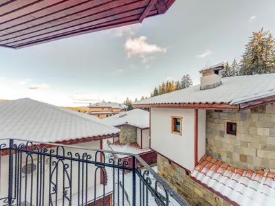 a balcony with snow on the roofs of buildings at Raikovski Livadi Mountain Villas Pamporovo in Smolyan