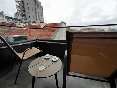 a small table and chairs on a balcony with a view at Barcelona 2BDR Cozy Apt w Working Space near Metro in Sofia