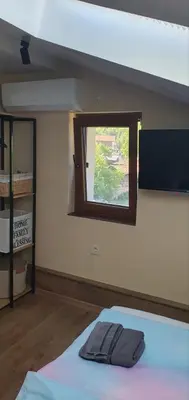 a room with a bed with a window and a tv at Къща за гости ОЗИ 3 in Ovchartsi